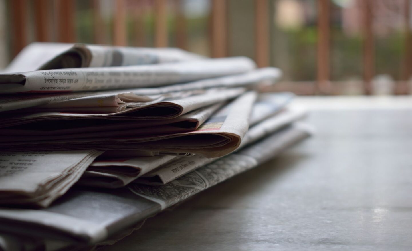 Novine i magazini složeni na redakcijskom stolu.