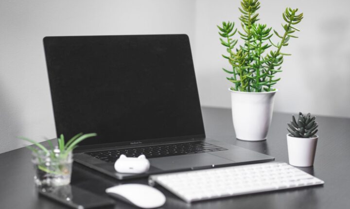 MacBook računar na urednom radnom stolu.